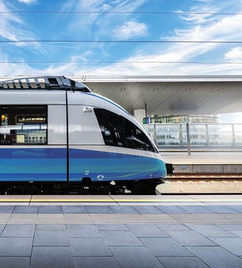 High speed train on the train station at sunset in Vienna, Austria. Beautiful red modern intercity passenger train on the railway platform, buildings. Side view. Railroad. Commercial transportation