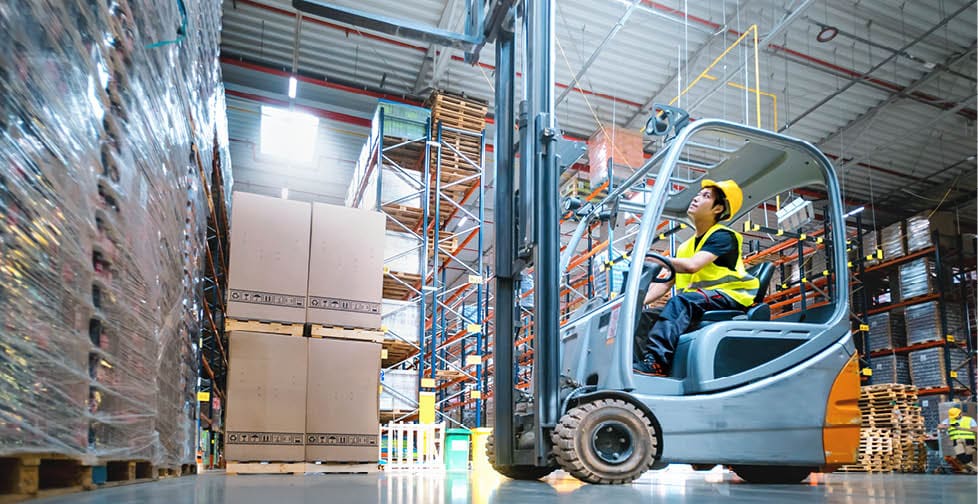 Warehouse worker operates a forklift